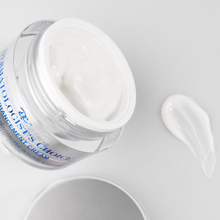 Open jar of Facial Enhancement Cream Mild Glycolic Daily Moisturizer | Dermatologist's Choice showing creamy white texture with a small amount swiped beside it on a light surface.