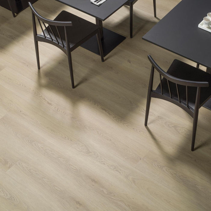 Wood effect luxury vinyl flooring with a dining table and chairs in the background.