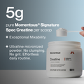 A hand holding a scoop of pure Momentous Signature Spec Creatine powder above an open container, highlighting The Momentous Three - Vegan supplement with exceptional mixability and ultrafine micronized powder.