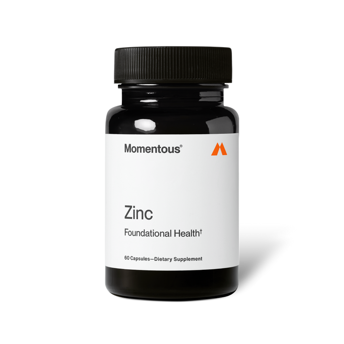Bottle of Zinc dietary supplement by Momentous with white label and black cap, promoting foundational health and wellness.